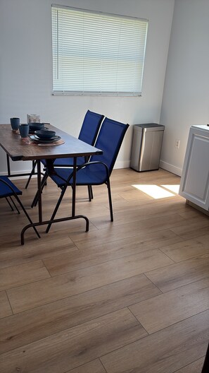 A dining area with a table, chairs, and a window with blinds. - Private 1-Bedroom Studio with Parking Near Orlando (Orlando)