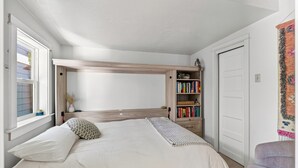 Un dormitorio con una litera, una estantería y una puerta.