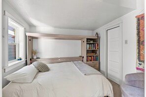Ein Schlafzimmer mit Etagenbett, Bücherregal und einer Tür.