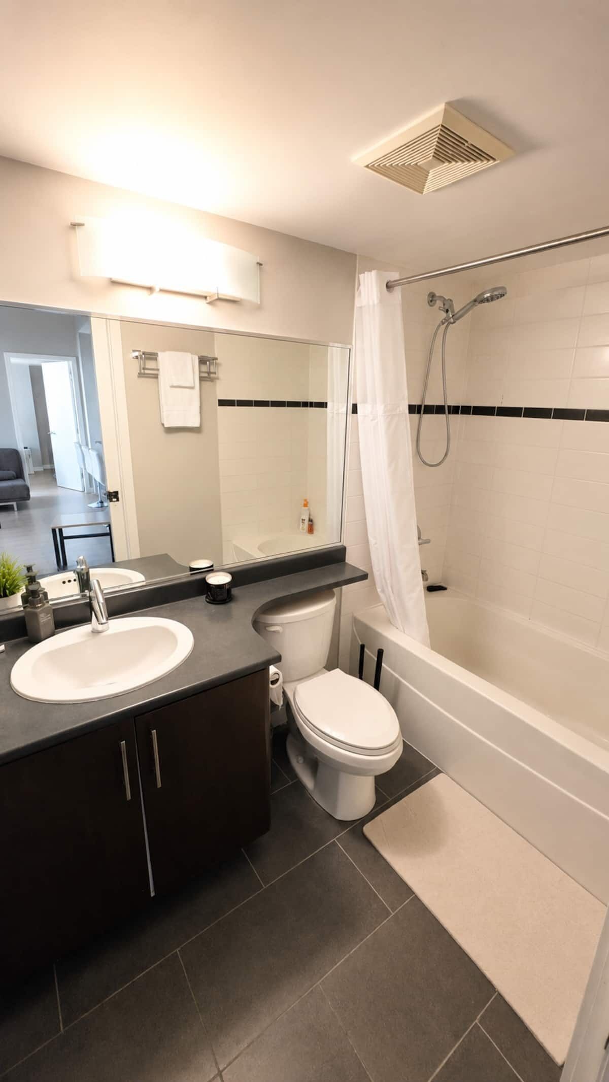 A modern bathroom with a bathtub, toilet, and sink.