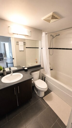 Een moderne badkamer met een bad, toilet en wastafel.