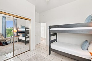 A bedroom with a bunk bed, a bedside table, a chair, and a mirror. - 5BR 30A Beach House Private Beach Access - Sleeps 10 (Santa Rosa Beach)