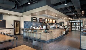 A modern cafe with a central bar area, seating arrangements, and a visible menu board. - Spacious Family Beach Stay | Pools, Hot Tubs & Ocean Views | Close to SkyWheel (Myrtle Beach)
