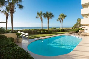A swimming pool with a view of the ocean, surrounded by palm trees and a well-maintained lawn. - Spacious Family Beach Stay | Pools, Hot Tubs & Ocean Views | Close to SkyWheel (Myrtle Beach)