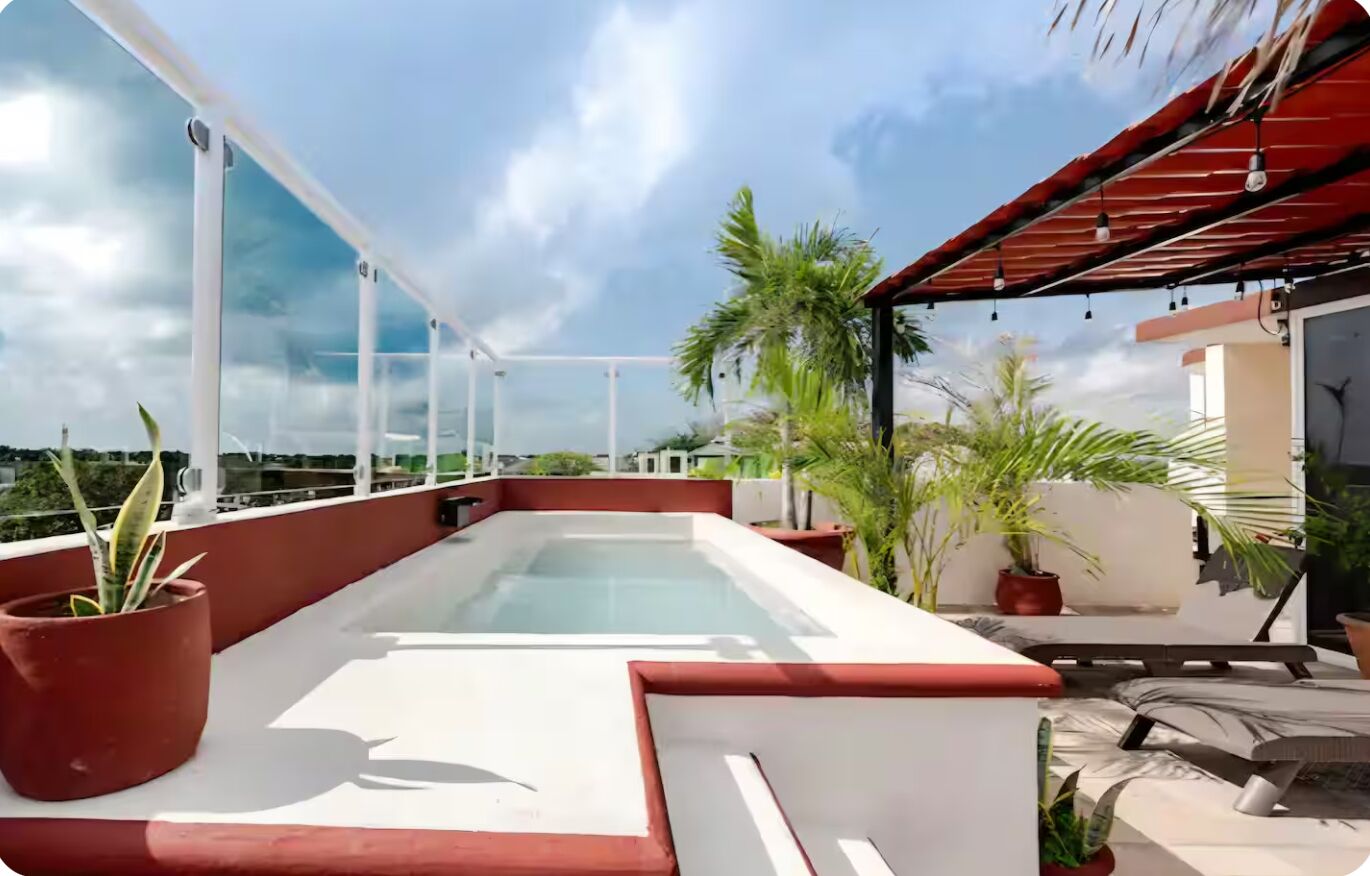 Eine Dachterrasse mit Pool, Kübelpflanzen und einer überdachten Sitzgelegenheit.