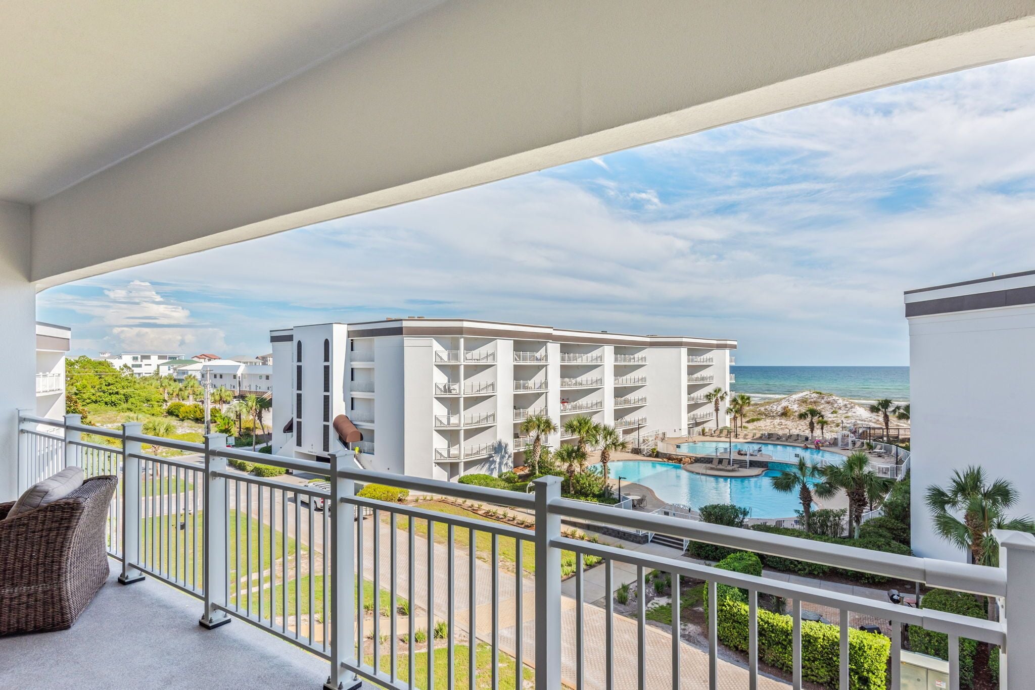 Een hotelbalkon met uitzicht op een zwembad en strand.