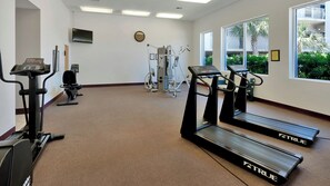 Ein Fitnessraum mit Laufbändern, einem Ergometer und Krafttrainingsgeräten.