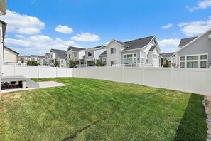 A residential area with houses, a white fence, and a well-maintained lawn.