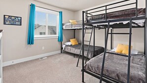 A room with bunk beds, a window with blinds, a picture on the wall, and a ceiling light. - Red Bridge Retreat | Gym | Ping-Pong | Near Golf (Eagle Mountain)