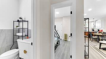 A modern bathroom with a toilet, sink, and towel rack.