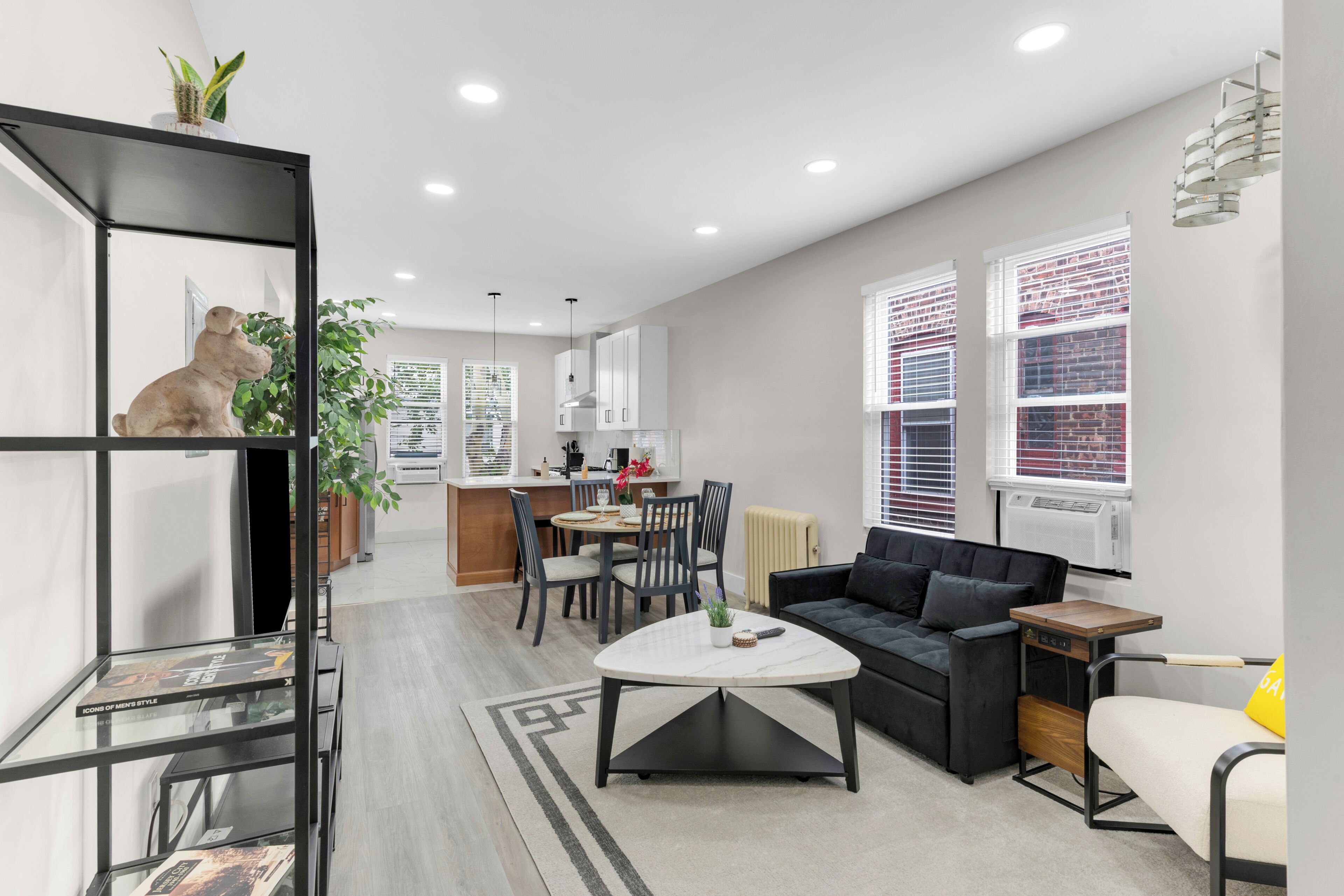 Un salon moderne comprenant un canapé, une table basse et un coin repas avec des chaises et une petite table.