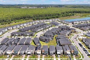 A residential area with multiple-story houses arranged in rows, surrounded by greenery and a body of water. - Stay in Style! 6BR Storey Lake Retreat with Pool & Spa (Kissimmee)