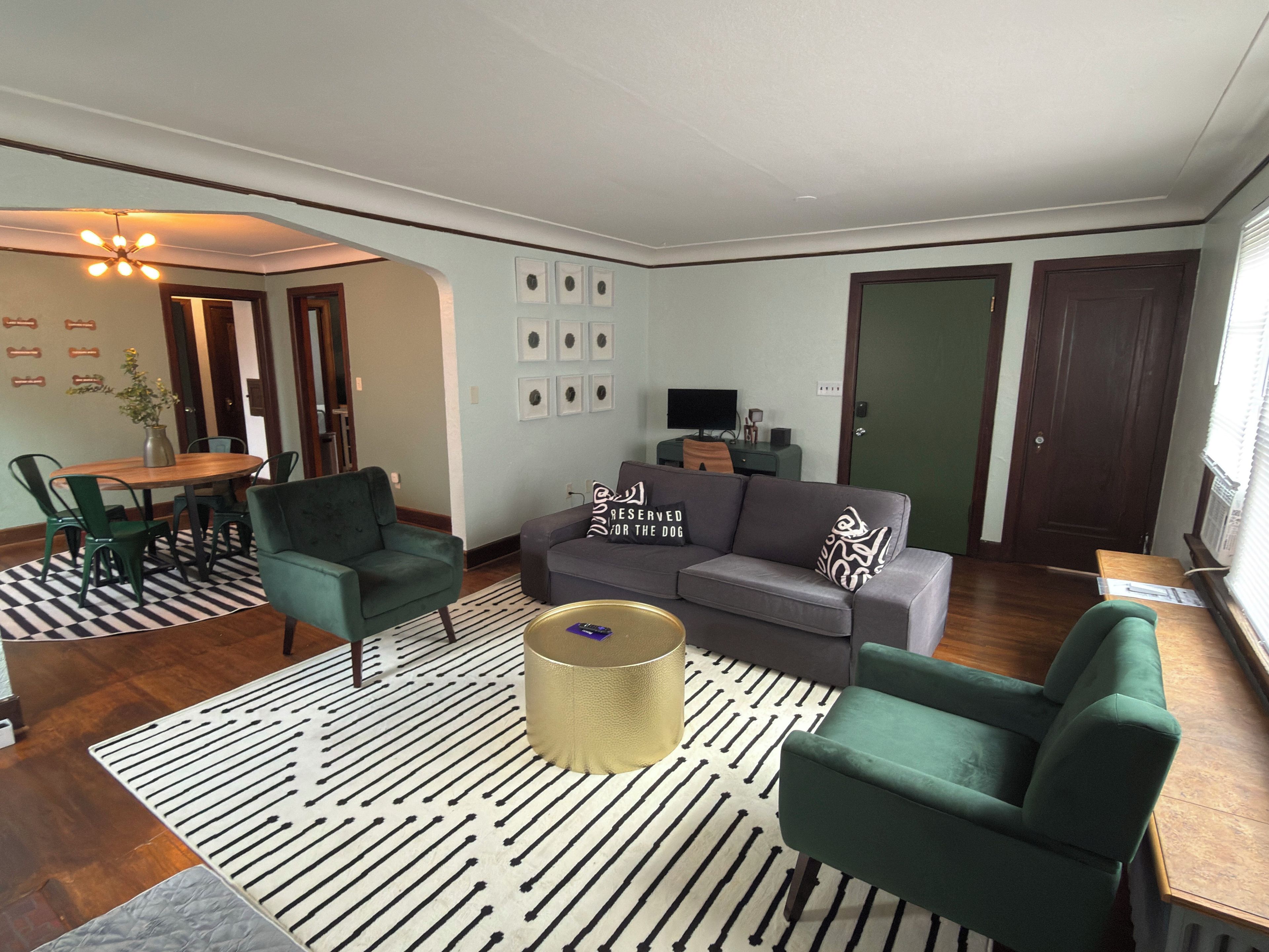 A living room with a sofa, chairs, a coffee table, and a dining area with a table and chairs.