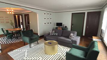 A living room with a sofa, chairs, a coffee table, and a dining area with a table and chairs.