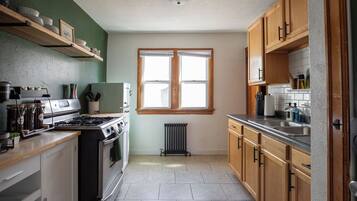 A kitchen with a stove, oven, and a window.