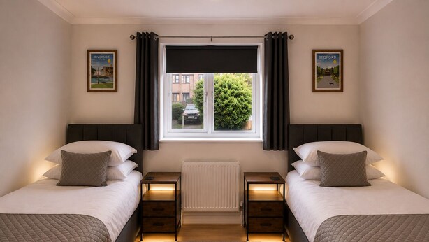 A double room with two beds, a window with curtains, a radiator, and two bedside tables with lamps. - Stylish 2-Bed Bedford Home | Sleeps 4 + Sofa Bed | Free Parking |Super Fast WiFi (Bedford)