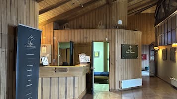 Un área de recepción con un mostrador de madera, un letrero que dice 'Casa Freude Hotel Boutique' y una barra de recepción.