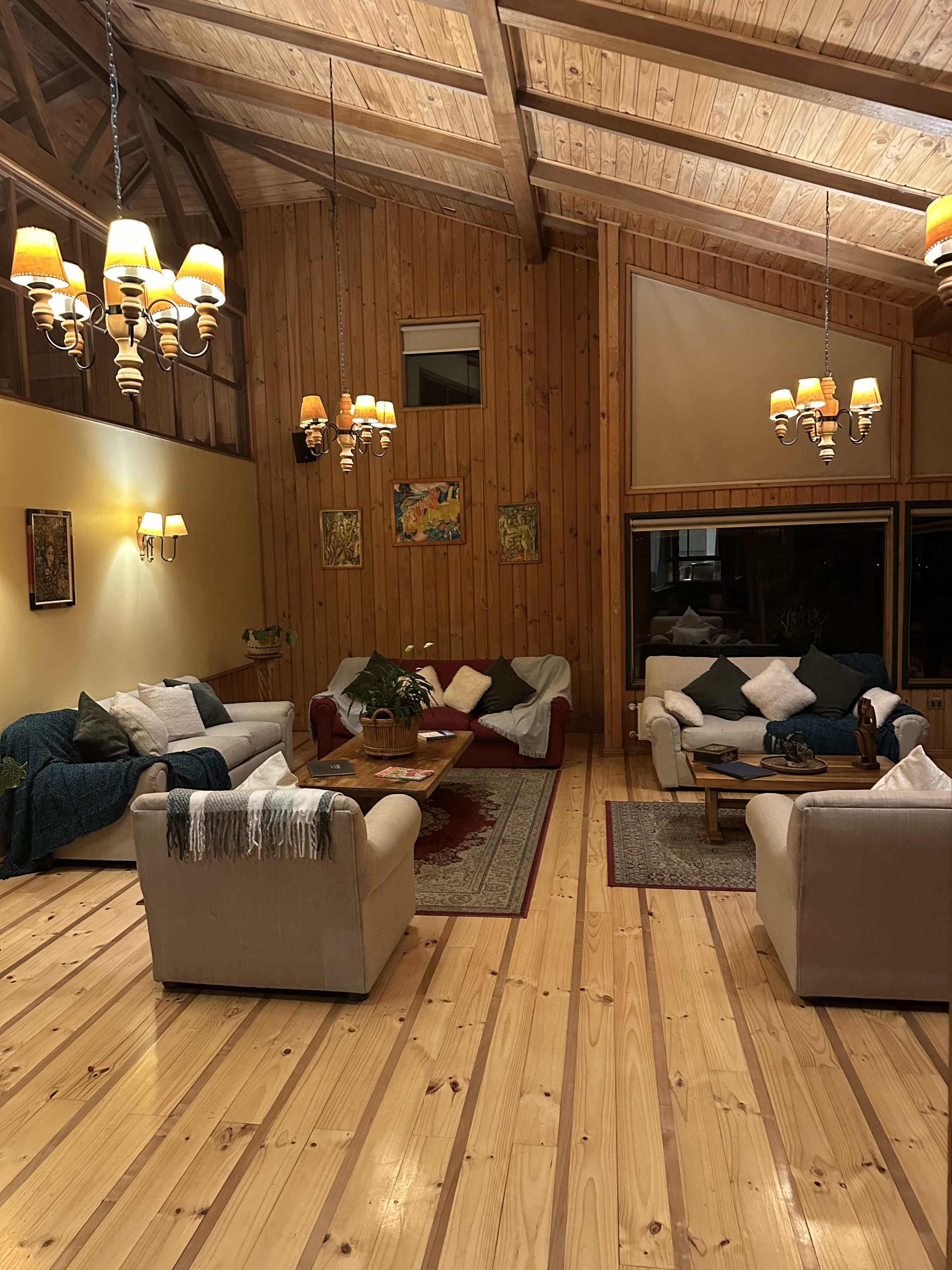 Un salon chaleureux avec un parquet, deux canapés, une table basse et une grande fenêtre.