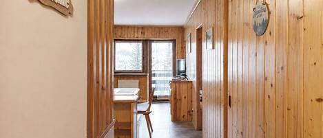 Interior de madera con un letrero que dice 'Welcome', un comedor y vistas a través de amplios ventanales.
