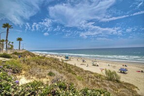 Una playa con palmeras, una torre de salvavidas y el océano.