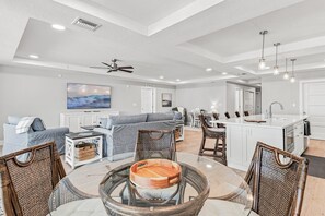 Una sala de estar amplia con comedor, cocina y ventilador de techo.
