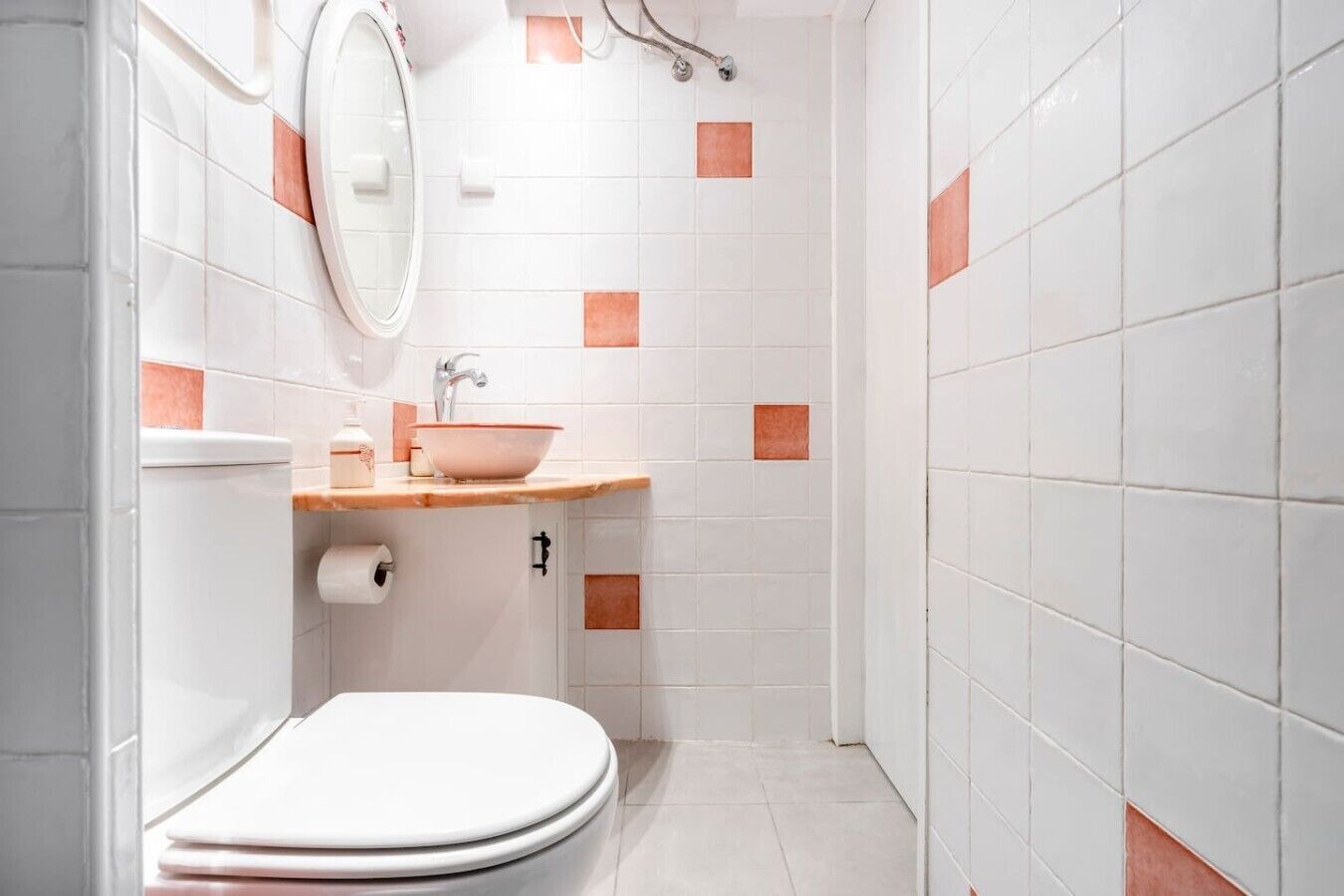 A bathroom with a toilet, sink, and shower area.