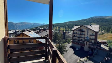 A hotel with a mountain view, a parking area, and a clear sky.