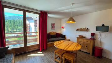 Una habitación acogedora con una mesa de comedor de madera, un sofá y un televisor.