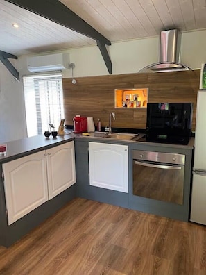 A compact kitchen with a built-in oven, a microwave, and a sink.
