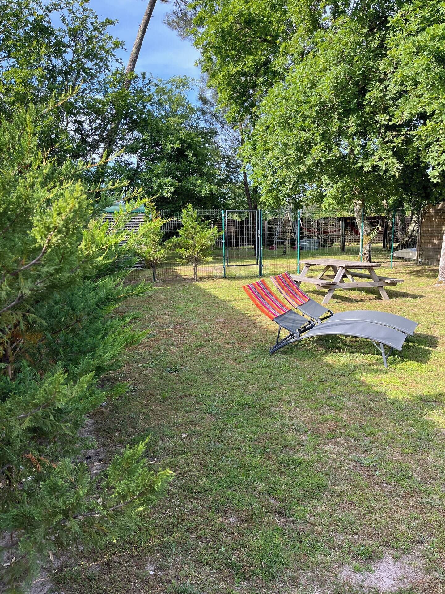 Un parc doté d’une aire de jeux clôturée, de tables de pique-nique et d’un hamac.