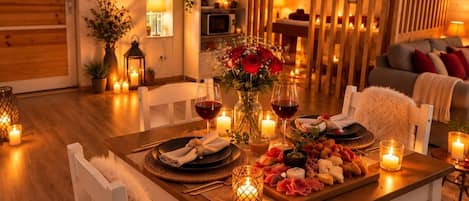 A cozy dining area with a wooden table set for a meal, surrounded by chairs.