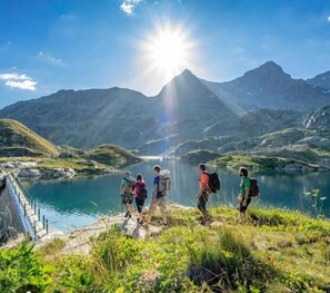 A group of people hiking near a lake with mountains in the background. - Magnifique studio au pied des montagnes (Prapoutel)
