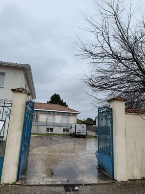 A gated entrance to a building with a van parked in front.