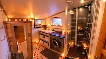 A bathroom with a shower, a sink, and a mirror.