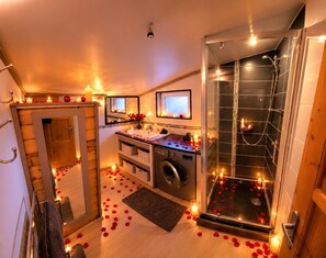 A bathroom with a shower, a sink, and a mirror.