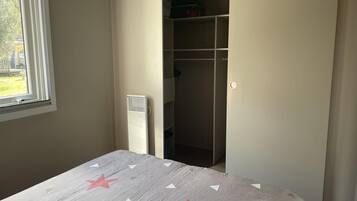 A bedroom with a bed, a window, and a closet.