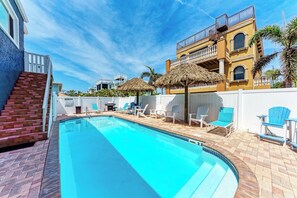 A swimming pool with lounge chairs and a staircase leading to a building. - Seagrass Shores Unit 3 (Bradenton Beach)