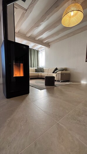Uma sala de estar moderna com lareira, um sofá e um lustre.