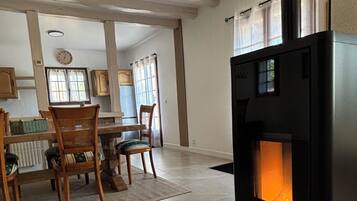 Een moderne woonkamer met een open haard, houten meubels en een groot raam.
