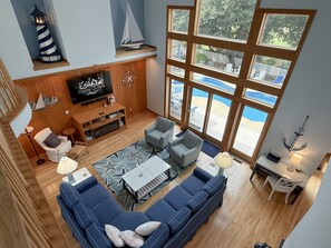 Ein geräumiges Wohnzimmer mit großem Fenster, einem Fernseher und einer Bootsdekoration.