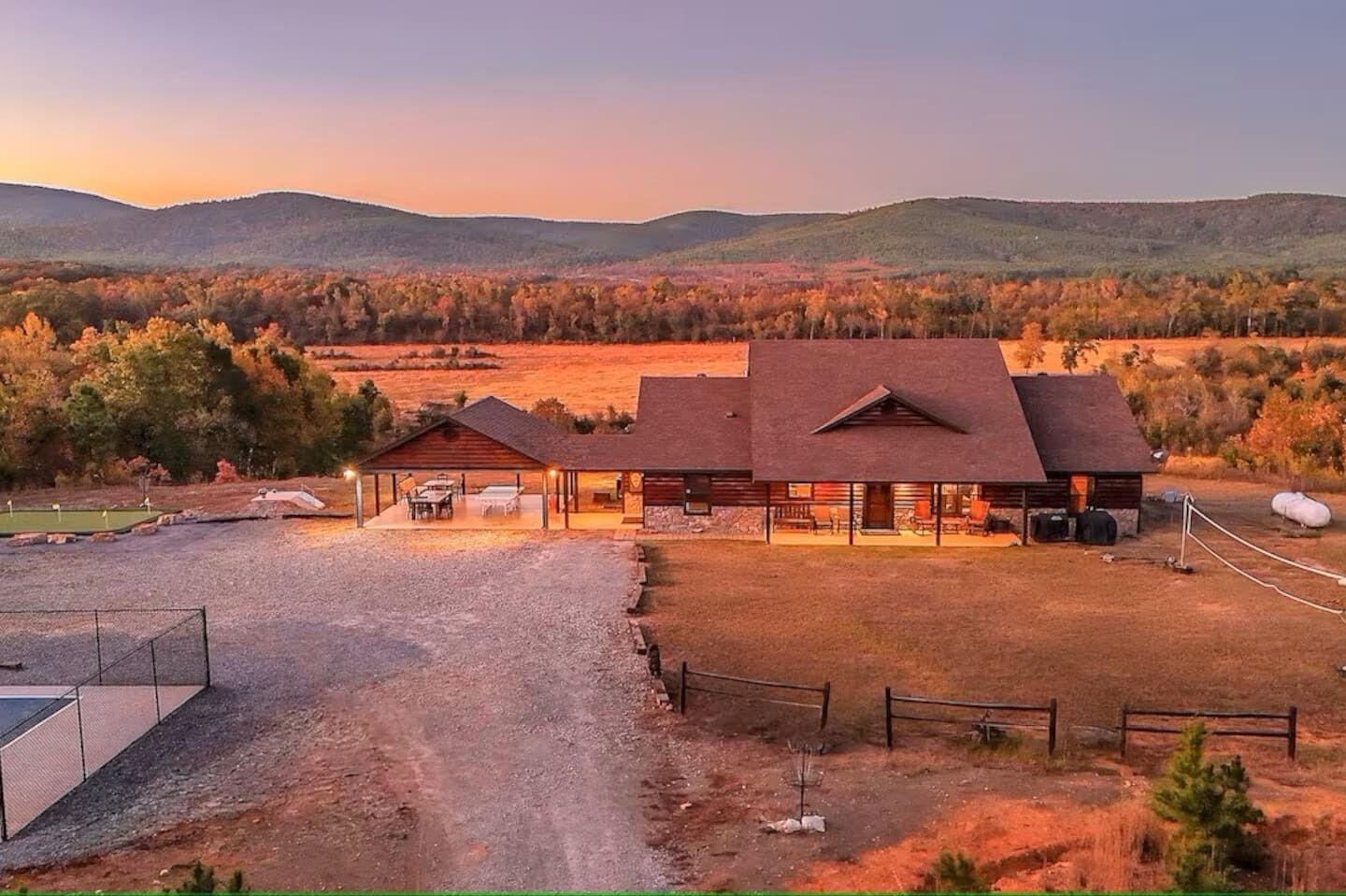 Wide aerial showing driveway, decks, and outdoor amenities.