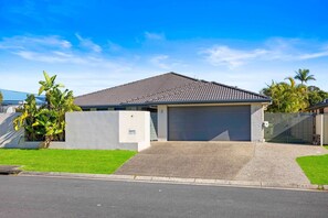 A residential house with a garage, a driveway, and a well-maintained lawn.