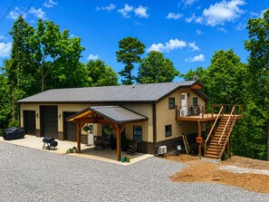 A two-story building with a covered porch, a staircase, and a garage.