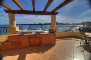 Una vasca idromassaggio con vista sull'oceano e sulle montagne.