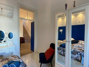 A bedroom with a bed, a chair, a wardrobe, and a staircase leading to another room. - casa BOA VIDA, 150 square meters for YOUR comfort (Olhão)