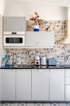 A kitchen with a built-in oven, a sink, and a decorative plant. - casa BOA VIDA, 150 square meters for YOUR comfort (Olhão)