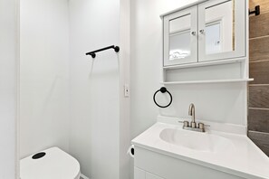 Ein Badezimmer mit Toilette, Waschbecken und einem Spiegel darüber.