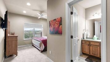 Un dormitorio con cama, ventana, ventilador de techo y cómoda de madera.