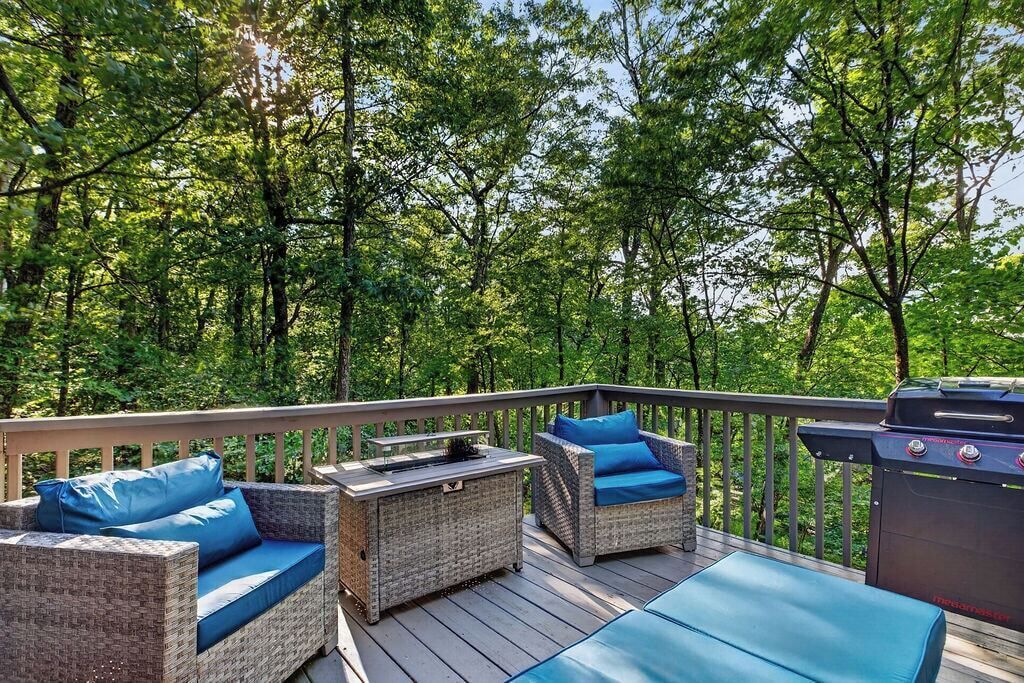 A deck with wicker furniture and a grill.