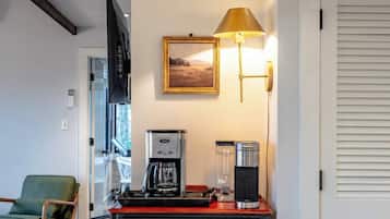 Ein Zimmer mit Kaffeemaschine, einer Lampe und einem gerahmten Bild an der Wand.